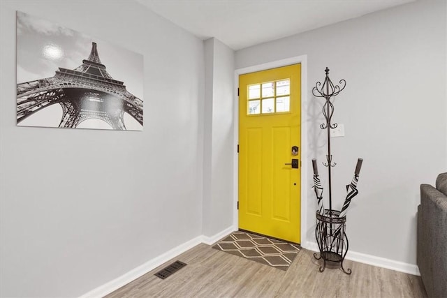 entrance foyer featuring baseboards, visible vents, and wood finished floors