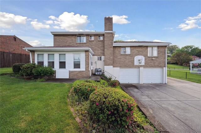 rear view of property featuring fence, an attached garage, a chimney, and driveway