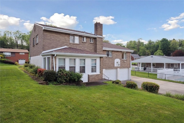 back of house with an attached garage, brick siding, driveway, and a chimney