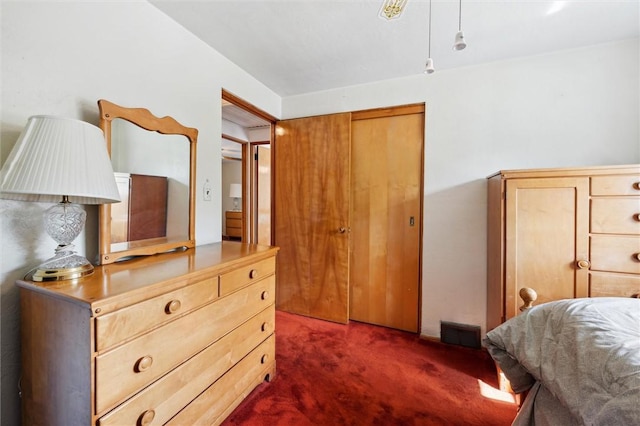 bedroom with dark colored carpet and visible vents