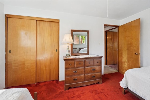 bedroom with dark carpet and a closet