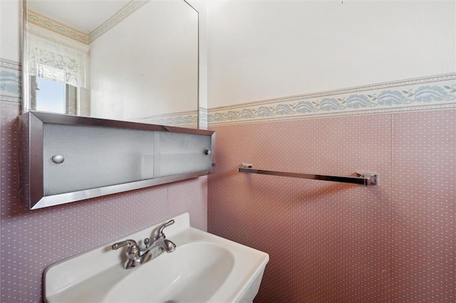 bathroom featuring ornamental molding and a sink