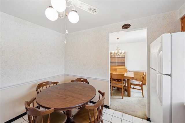 dining area with light tile patterned floors, a chandelier, and wallpapered walls