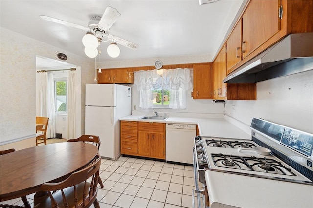 kitchen featuring a sink, brown cabinetry, white appliances, and under cabinet range hood