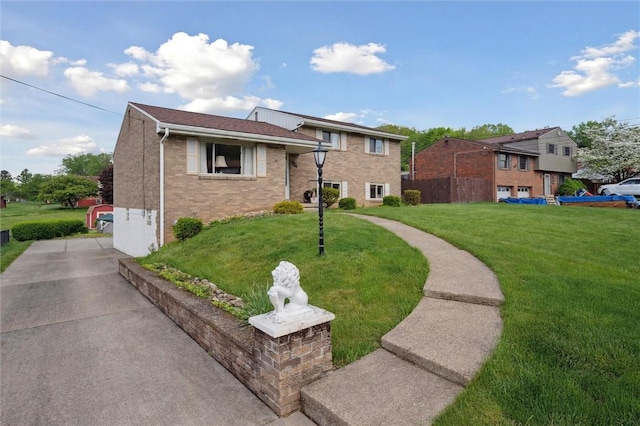 split level home with brick siding, driveway, and a front yard