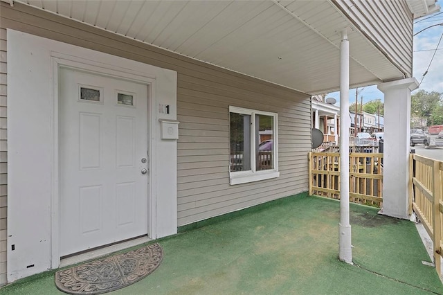 doorway to property featuring a yard and a porch