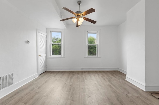 unfurnished room with light wood-type flooring, baseboards, a ceiling fan, and a healthy amount of sunlight
