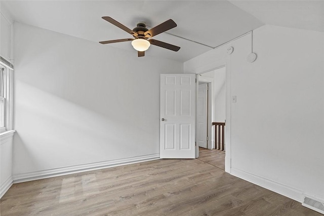spare room featuring a ceiling fan, baseboards, visible vents, and wood finished floors