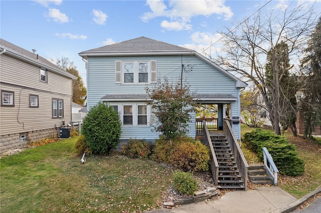 view of front facade featuring cooling unit, a front yard, and stairway