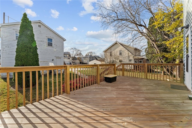 wooden deck with a residential view, an outbuilding, and a storage unit