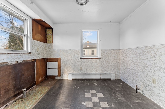 spare room featuring a baseboard heating unit, a wainscoted wall, and crown molding