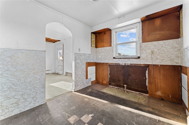 kitchen featuring a baseboard radiator, arched walkways, and crown molding