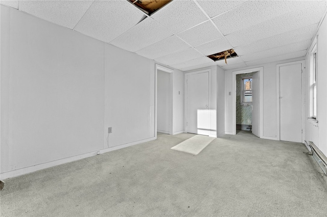 unfurnished bedroom featuring a paneled ceiling, carpet floors, and baseboards