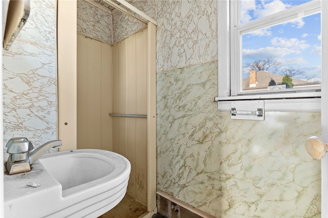 bathroom featuring wallpapered walls and a sink