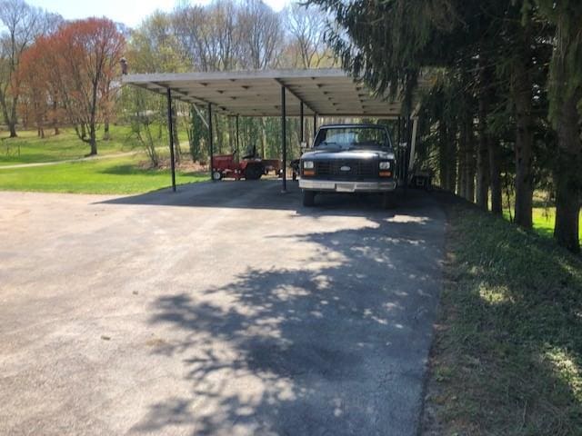 view of parking with a detached carport and aphalt driveway