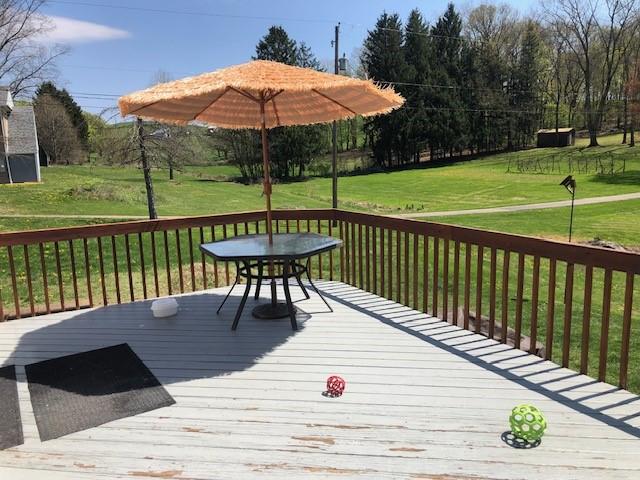 wooden terrace with a lawn