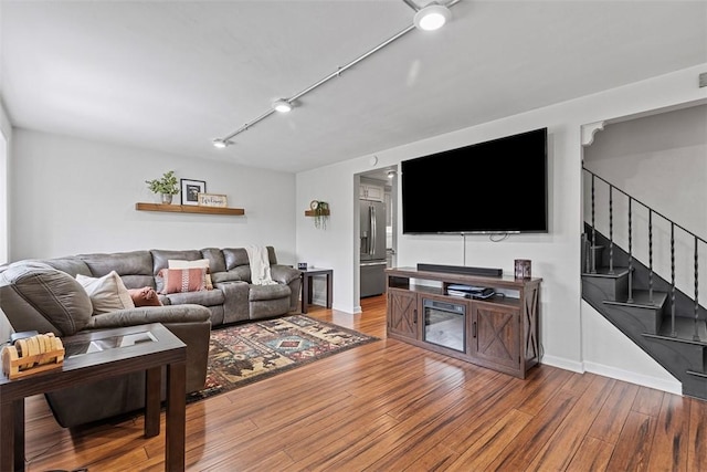 living room with stairway and wood finished floors