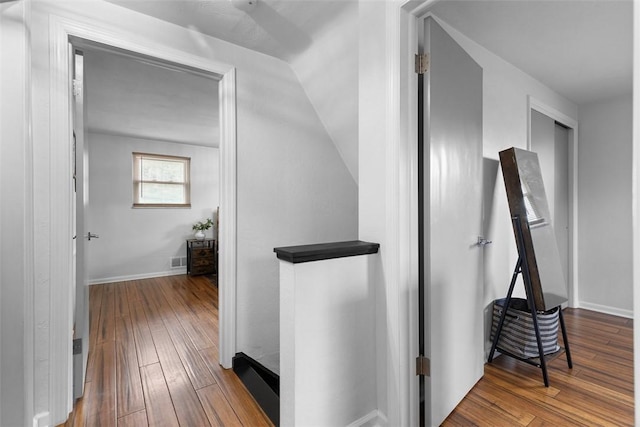 hallway featuring visible vents, baseboards, and hardwood / wood-style floors