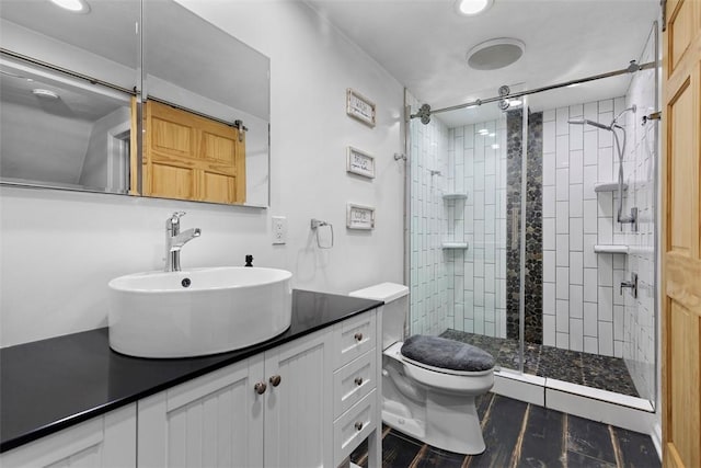 bathroom with vanity, toilet, a shower stall, and recessed lighting