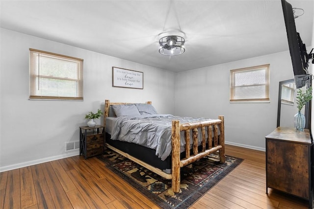 bedroom featuring multiple windows, visible vents, and hardwood / wood-style flooring