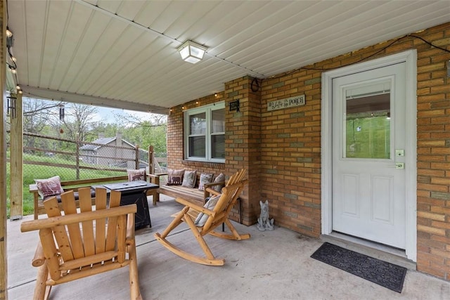 view of patio / terrace with an outdoor living space with a fire pit and fence