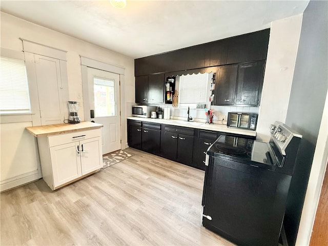 1415 E Washington St, New Castle/4Th, PA 16101 - kitchen featuring stainless steel microwave, a sink, butcher block counters, light wood finished floors, and electric range