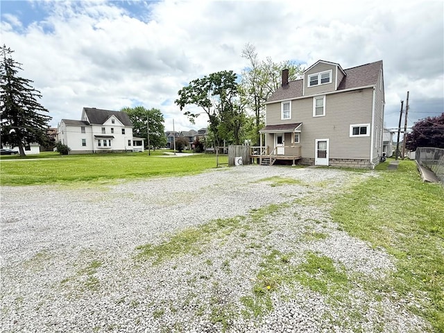 1415 E Washington St, New Castle/4Th, PA 16101 - back of house with roof with shingles, a wooden deck, a chimney, gravel driveway, and a lawn