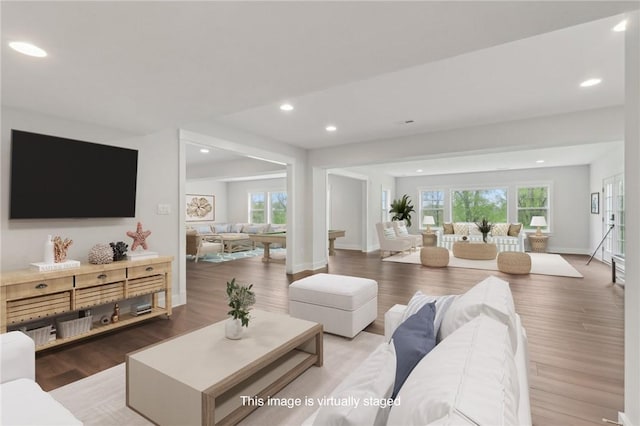 living room featuring a wealth of natural light, wood finished floors, baseboards, and recessed lighting
