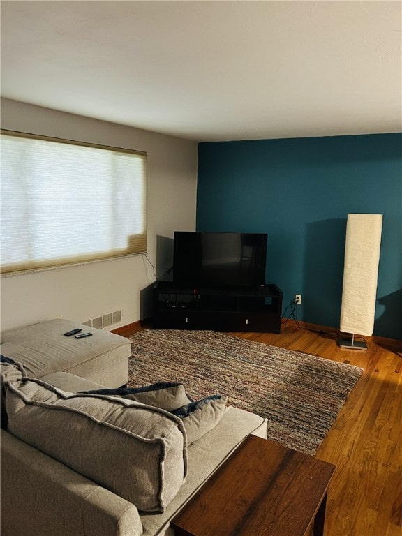 living area with visible vents and wood finished floors