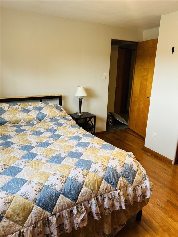 bedroom with baseboards and wood finished floors