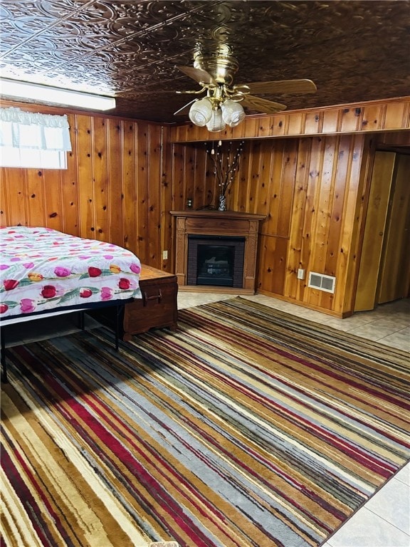 bedroom featuring a fireplace, an ornate ceiling, wood walls, and visible vents