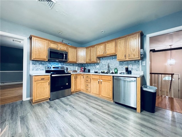 kitchen with light countertops, appliances with stainless steel finishes, visible vents, and light wood-style flooring