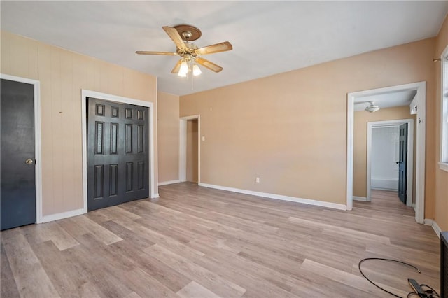 unfurnished bedroom with light wood finished floors, a closet, baseboards, and a ceiling fan