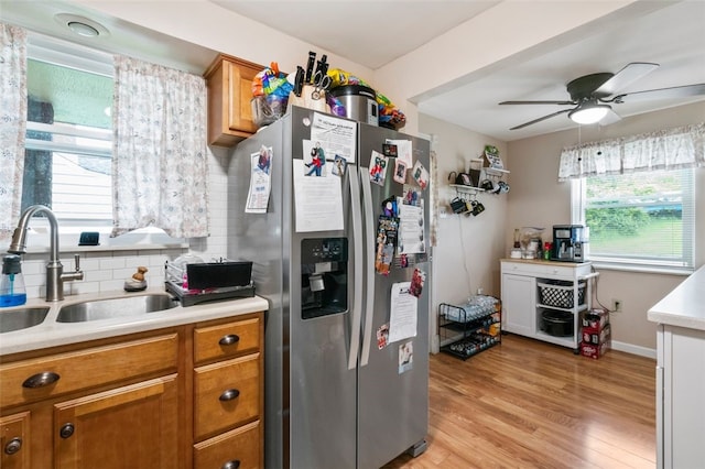 kitchen featuring a sink, brown cabinetry, stainless steel fridge with ice dispenser, and light countertops