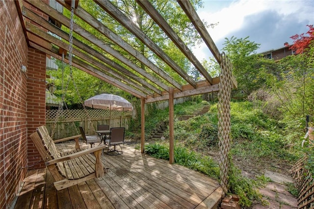 wooden terrace featuring outdoor dining space, a pergola, and fence