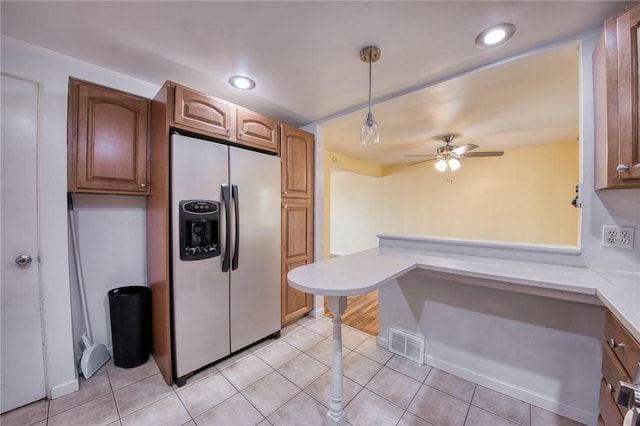 kitchen featuring light tile patterned floors, ceiling fan, visible vents, stainless steel refrigerator with ice dispenser, and light countertops