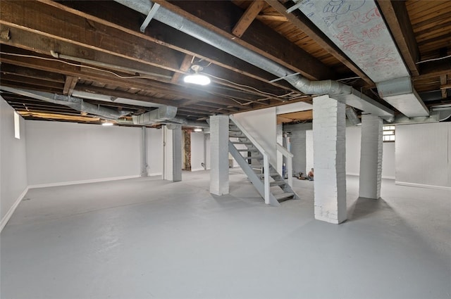 below grade area featuring stairway and baseboards