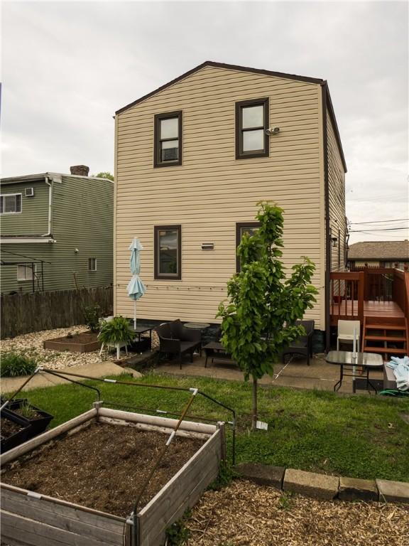 6518 Adelphia St, Stanton Heights, PA 15206 - rear view of property featuring a deck, outdoor lounge area, and a vegetable garden