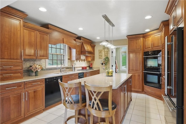 kitchen with brown cabinetry, black appliances, and a sink