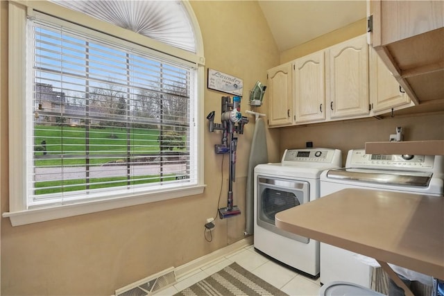 washroom featuring a wealth of natural light, separate washer and dryer, visible vents, and cabinet space