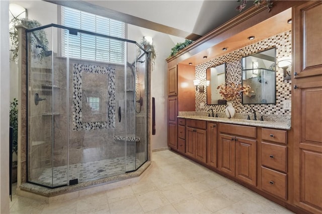 full bathroom featuring double vanity, decorative backsplash, a shower stall, and a sink
