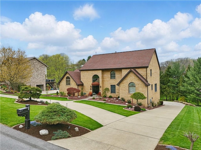 view of front of property featuring a front lawn and curved driveway
