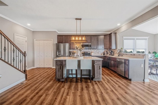 2623 Arno Dr, Oakdale, PA 15071 - kitchen with a sink, stainless steel appliances, wood finished floors, light countertops, and dark brown cabinets