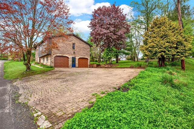 43 Mckrell Rd, West Deer, PA 15076 - view of home's exterior featuring stone siding, decorative driveway, a garage, and a yard