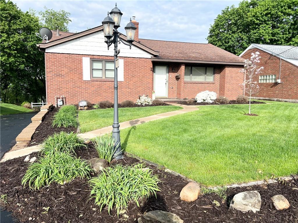 view of front of property featuring a front lawn, brick siding, and a chimney
