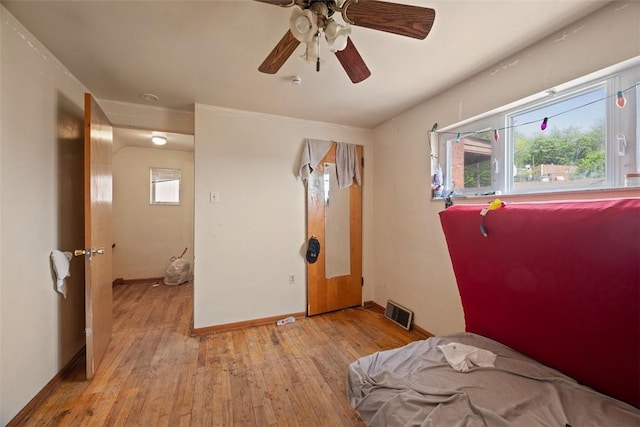 bedroom featuring light wood finished floors, baseboards, a ceiling fan, and visible vents