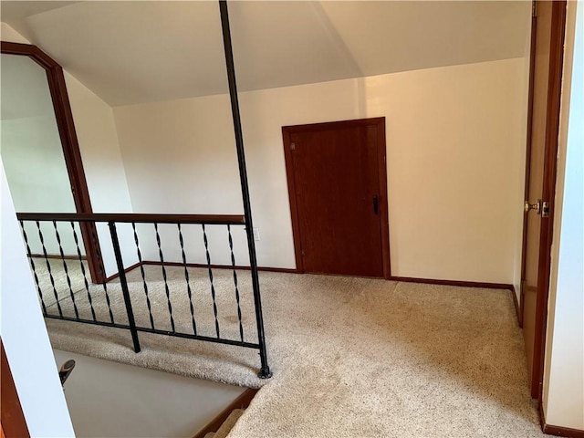 stairs featuring lofted ceiling, carpet, and baseboards