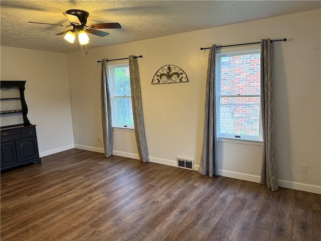 unfurnished living room with a textured ceiling, baseboards, ceiling fan, visible vents, and wood finished floors