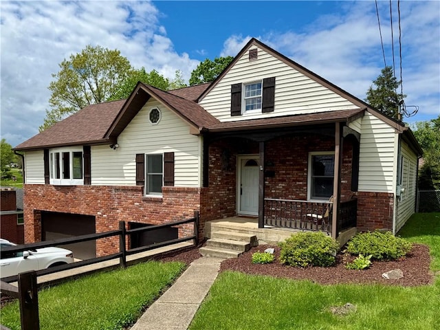 bungalow-style house featuring covered porch, roof with shingles, fence, and brick siding