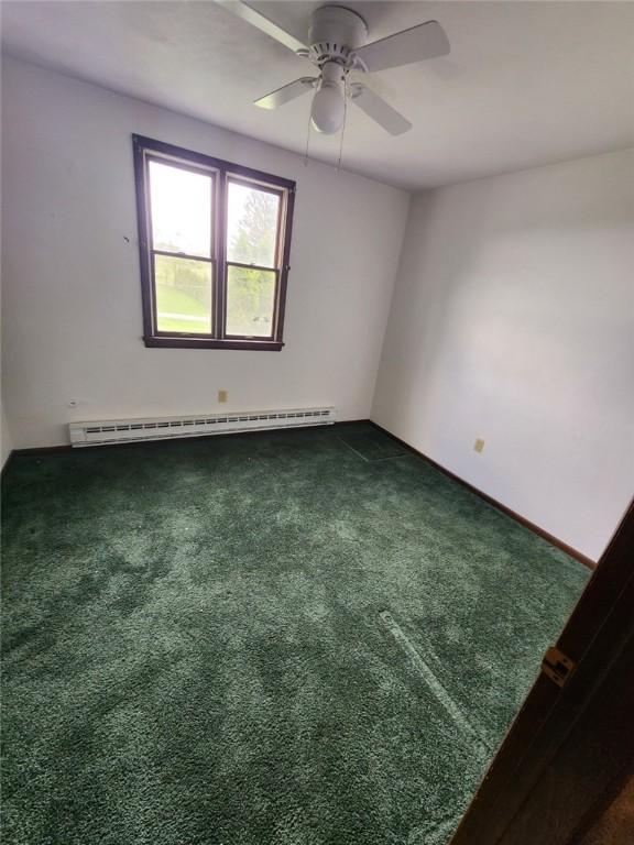 219 Meadow Dr, Westmont Hilltop School District, PA 15905 - unfurnished room featuring a ceiling fan, a baseboard radiator, dark colored carpet, and baseboards
